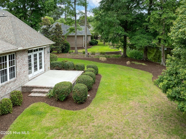 2788 Creek Bridge Ct, Southport, NC 28461 - view of green lawn with french doors and a patio area