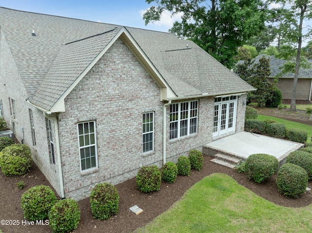 2788 Creek Bridge Ct, Southport, NC 28461 - rear view of property with french doors, a shingled roof, a patio, and brick siding