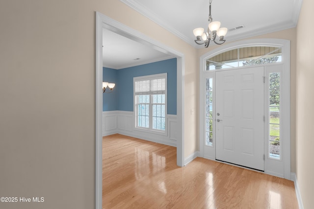2788 Creek Bridge Ct, Southport, NC 28461 - foyer entrance featuring a chandelier, wood finished floors, ornamental molding, and wainscoting