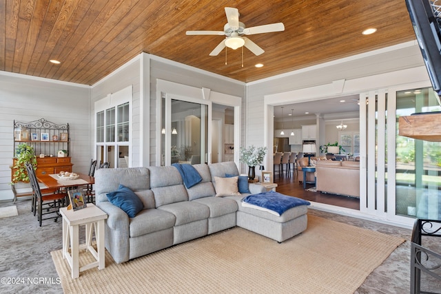 living room with wood walls, wooden ceiling, ceiling fan with notable chandelier, and hardwood / wood-style flooring