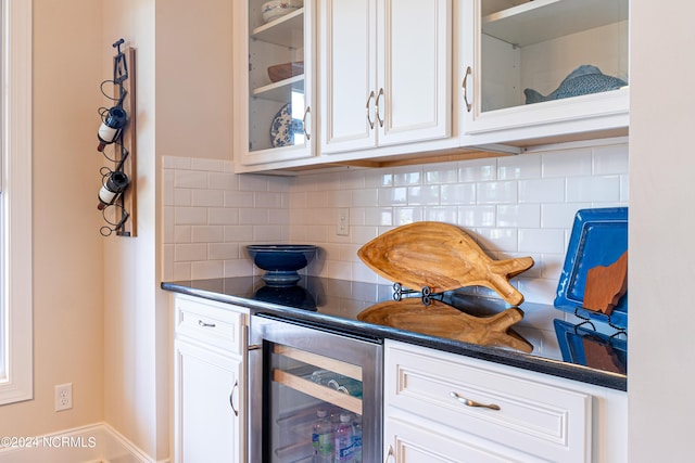 kitchen featuring decorative backsplash, white cabinetry, and wine cooler