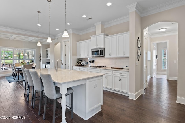 kitchen featuring a center island with sink, sink, dark hardwood / wood-style floors, white cabinetry, and stainless steel appliances