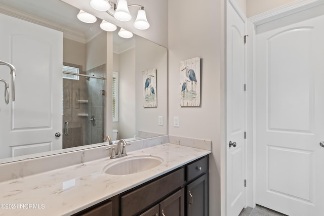 bathroom featuring ornamental molding, vanity, toilet, and a shower with shower door