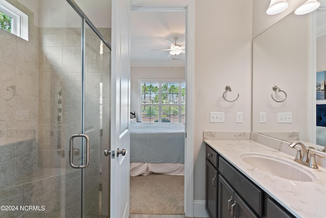 bathroom with ceiling fan, plenty of natural light, a shower with door, and ornamental molding