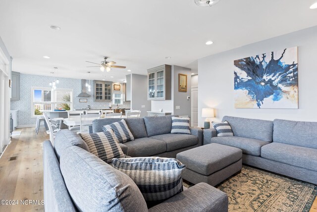 living room featuring ceiling fan and light hardwood / wood-style floors