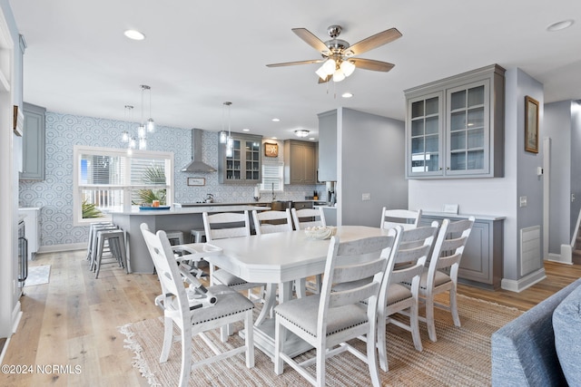 dining area featuring light hardwood / wood-style floors and ceiling fan with notable chandelier