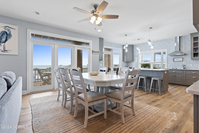 dining space with light wood-type flooring and ceiling fan