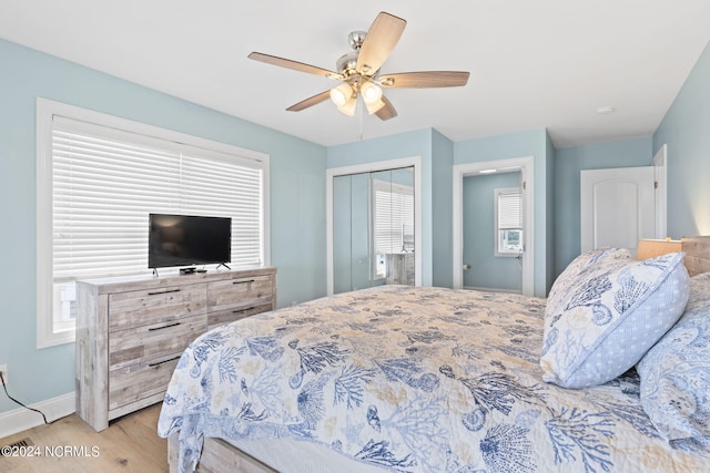 bedroom featuring multiple windows, a closet, light hardwood / wood-style flooring, and ceiling fan