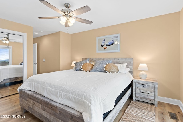 bedroom featuring light hardwood / wood-style floors, ceiling fan, and a closet