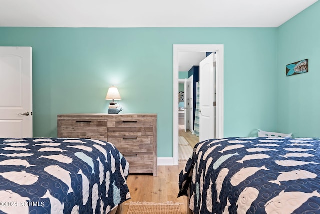 bedroom with light hardwood / wood-style flooring and ensuite bath