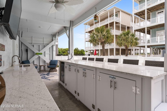 view of patio / terrace featuring ceiling fan, sink, and a balcony