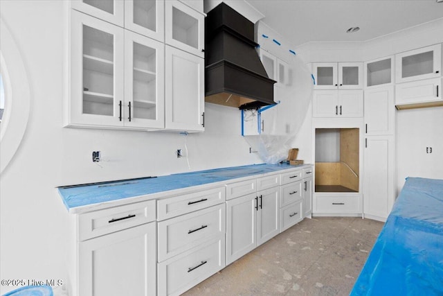 kitchen with custom range hood and white cabinets