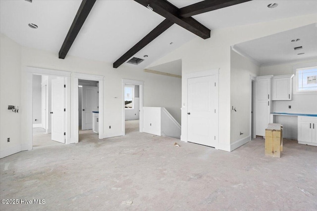 unfurnished bedroom with lofted ceiling with beams and ensuite bath