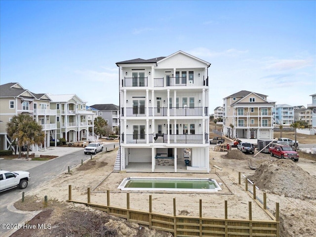 back of property featuring a patio, a balcony, and a jacuzzi