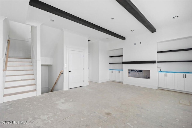 unfurnished living room with beam ceiling