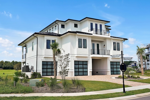 view of front facade with an attached garage, board and batten siding, a standing seam roof, metal roof, and a balcony