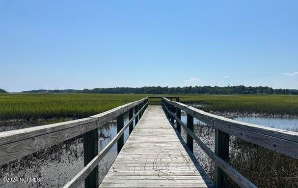 view of dock with a rural view and a water view