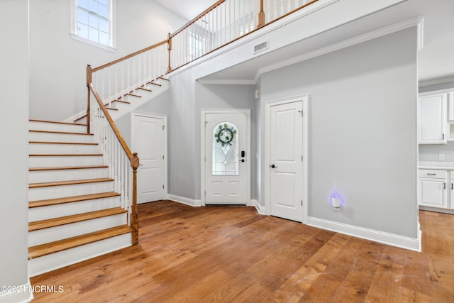 foyer featuring light hardwood / wood-style flooring and crown molding