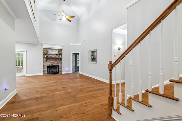 unfurnished living room featuring hardwood / wood-style flooring, ornamental molding, ceiling fan, and high vaulted ceiling