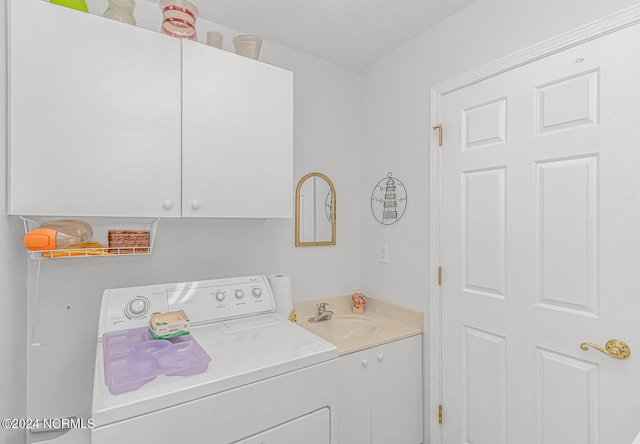 laundry area with sink, washer and clothes dryer, and cabinets