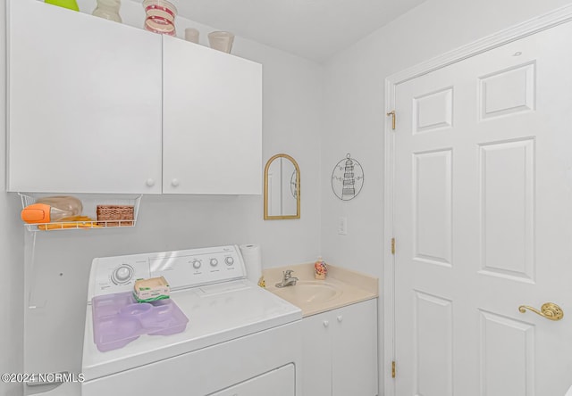 clothes washing area with a sink, cabinet space, and washer and dryer