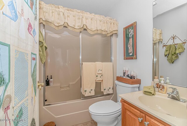 full bathroom featuring shower / bath combination with glass door, tile patterned floors, toilet, and vanity