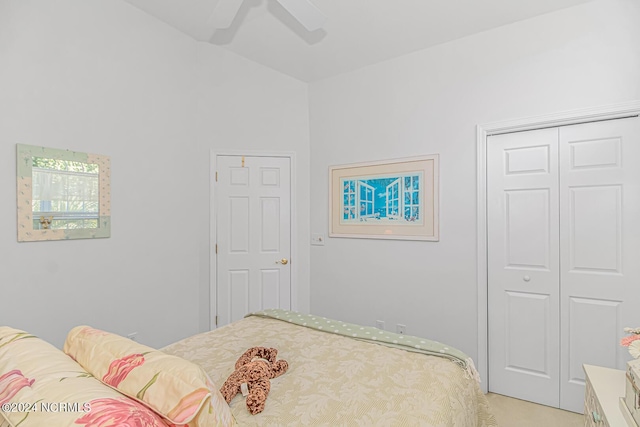 bedroom featuring a ceiling fan, a closet, light colored carpet, and vaulted ceiling