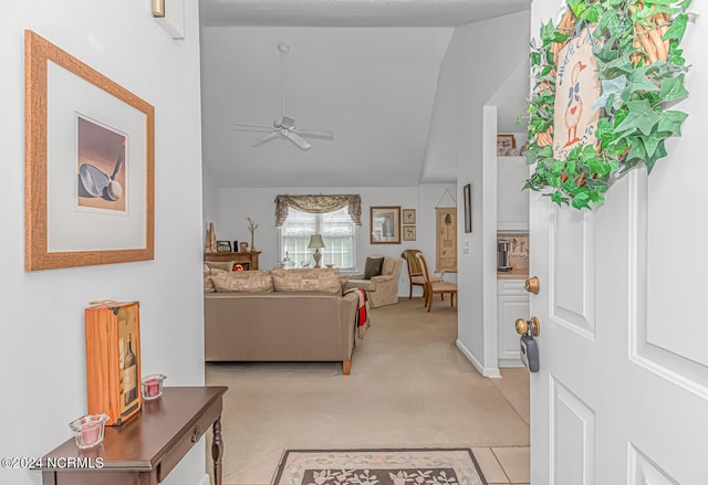 tiled living room with ceiling fan and high vaulted ceiling