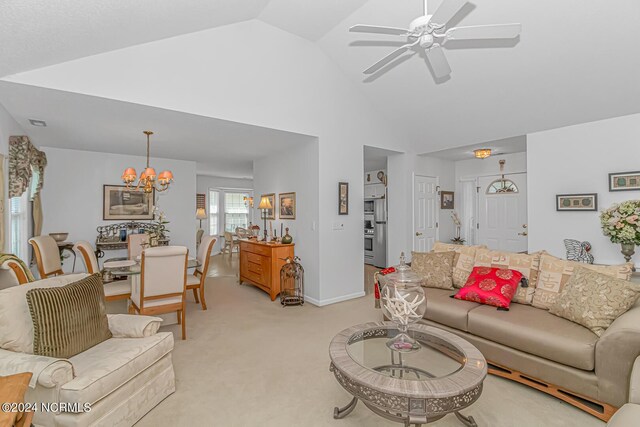 living room with light colored carpet, high vaulted ceiling, and ceiling fan with notable chandelier