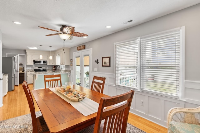 142 Carolina Ave, Holden Beach, NC 28462 - dining room with a wainscoted wall, french doors, recessed lighting, ceiling fan, and light wood-style flooring
