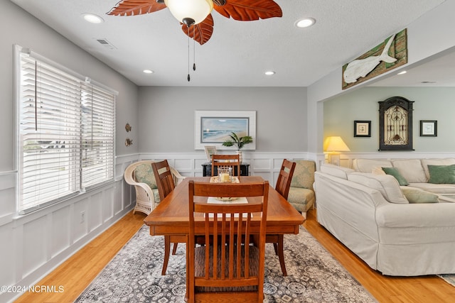 dining room featuring a textured ceiling, recessed lighting, a wainscoted wall, visible vents, and light wood-style floors