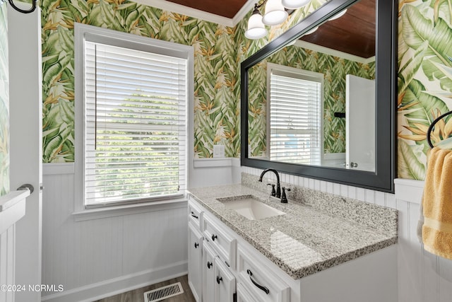 bathroom with wainscoting, vanity, visible vents, and wallpapered walls