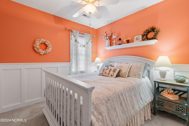 142 Carolina Ave, Holden Beach, NC 28462 - carpeted bedroom featuring a wainscoted wall, a decorative wall, and ceiling fan