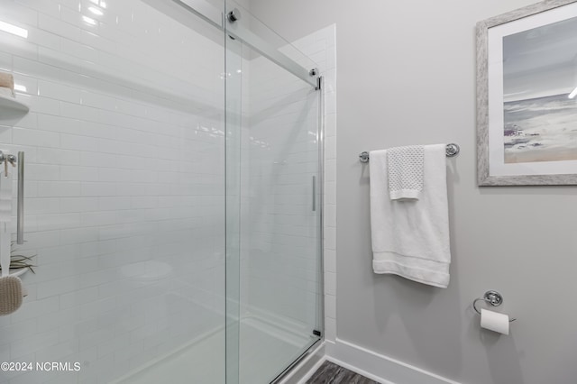 bathroom with hardwood / wood-style floors and a shower with shower door