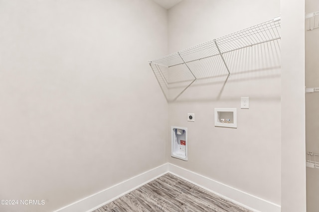 clothes washing area with hookup for a washing machine, hardwood / wood-style floors, and electric dryer hookup