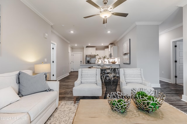 living room featuring ornamental molding, wood-type flooring, and ceiling fan