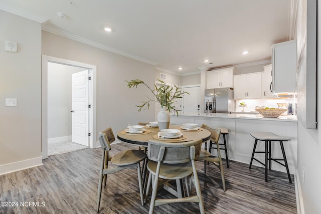 dining area featuring dark wood-type flooring and ornamental molding