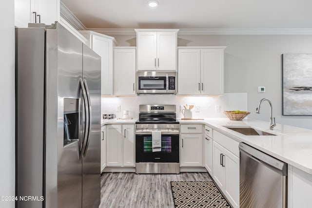 kitchen featuring stainless steel appliances, light hardwood / wood-style floors, white cabinetry, and sink