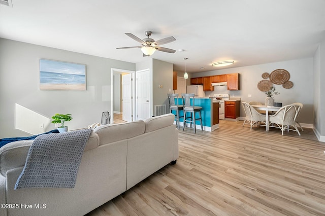 kitchen featuring kitchen peninsula, ceiling fan, white appliances, hanging light fixtures, and sink