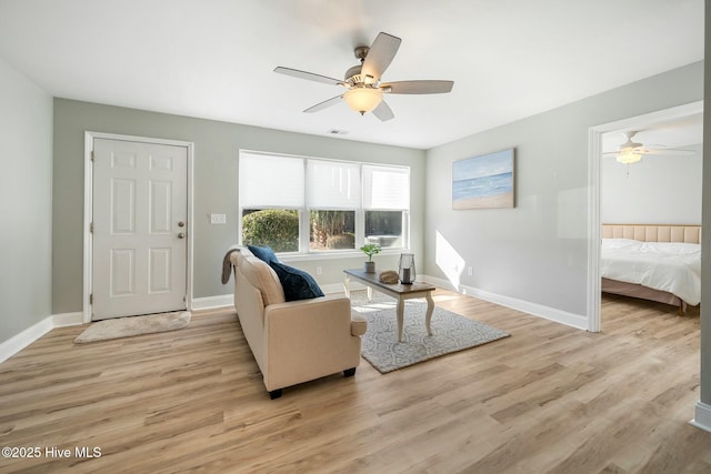 living room with ceiling fan and light hardwood / wood-style flooring