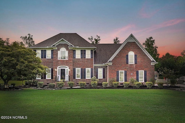 colonial-style house featuring a lawn