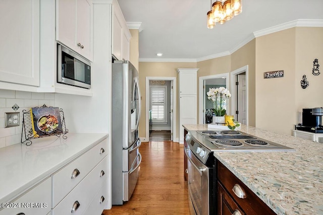 kitchen featuring ornamental molding, dark brown cabinets, stainless steel appliances, light hardwood / wood-style flooring, and white cabinets