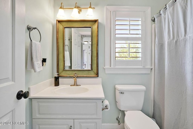 bathroom with curtained shower, vanity, and toilet