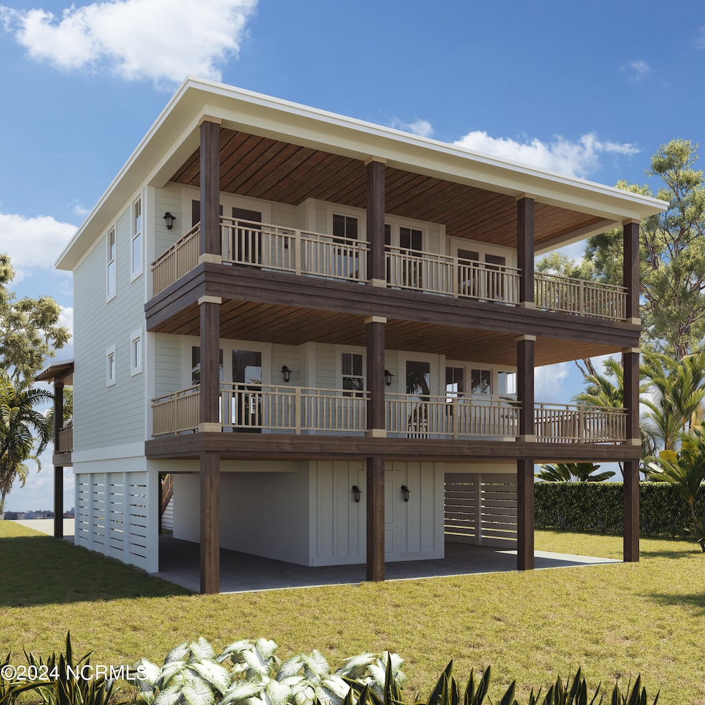 rear view of house with a balcony, a garage, and a yard