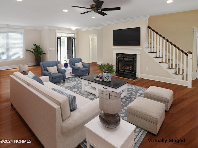 living room featuring wood-type flooring, plenty of natural light, and ornamental molding