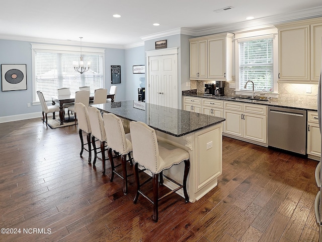 kitchen with pendant lighting, sink, a kitchen island, cream cabinetry, and dishwasher