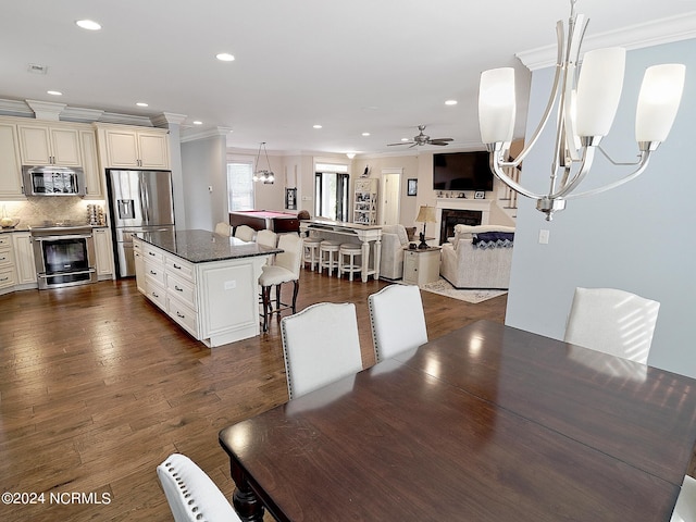 dining room featuring ceiling fan, dark wood-type flooring, and crown molding