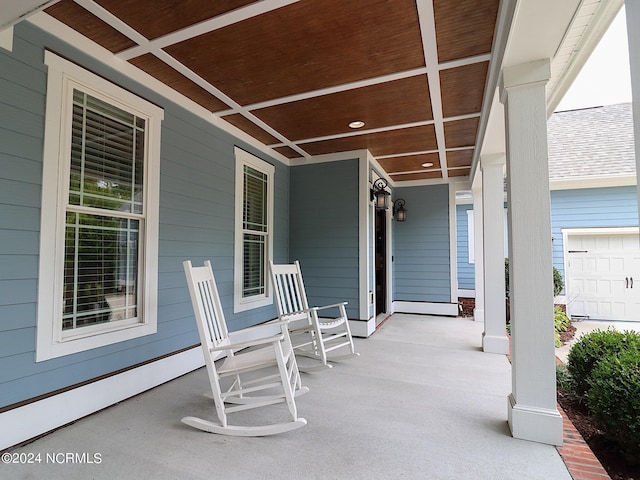 view of patio / terrace with a porch and a garage