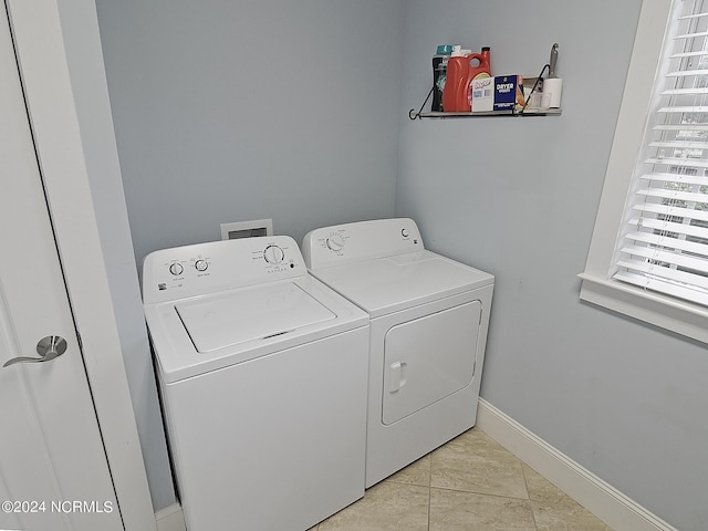 laundry area with separate washer and dryer and light tile patterned floors