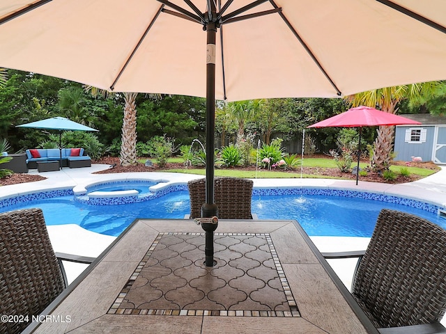 view of swimming pool with a storage shed, an in ground hot tub, pool water feature, and a patio area